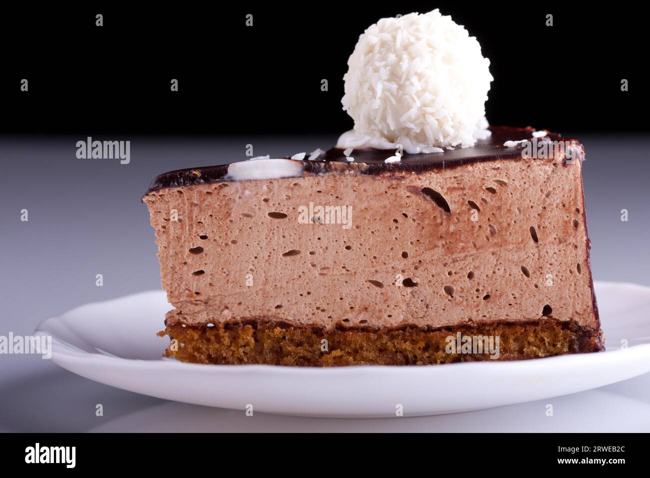 Gustosa torta al cioccolato sul piatto su sfondo astratto. Messa a fuoco superficiale Foto Stock