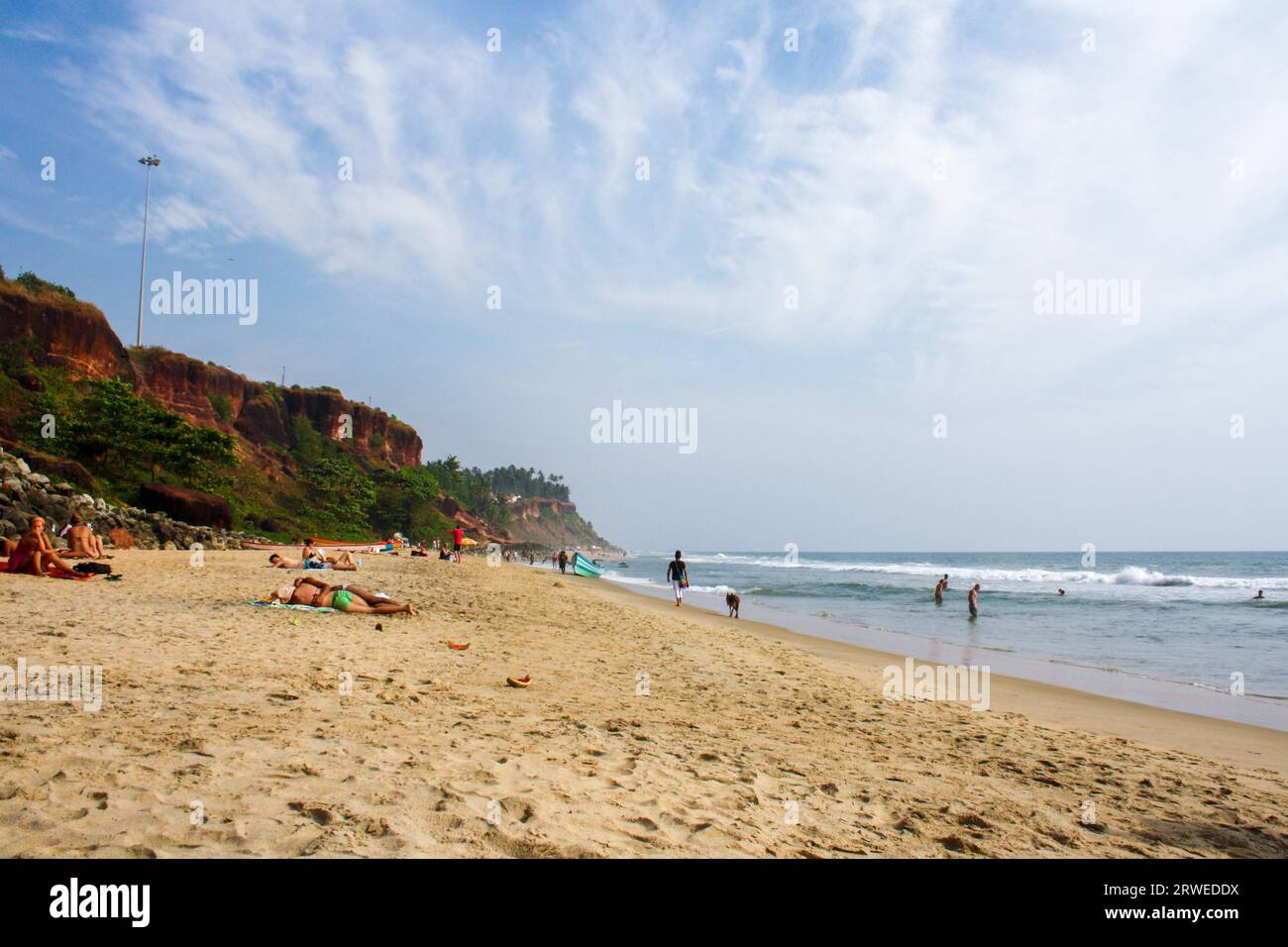Varkala, India, 1 febbraio 2011: Persone che si rilassano sulla spiaggia di sabbia Foto Stock