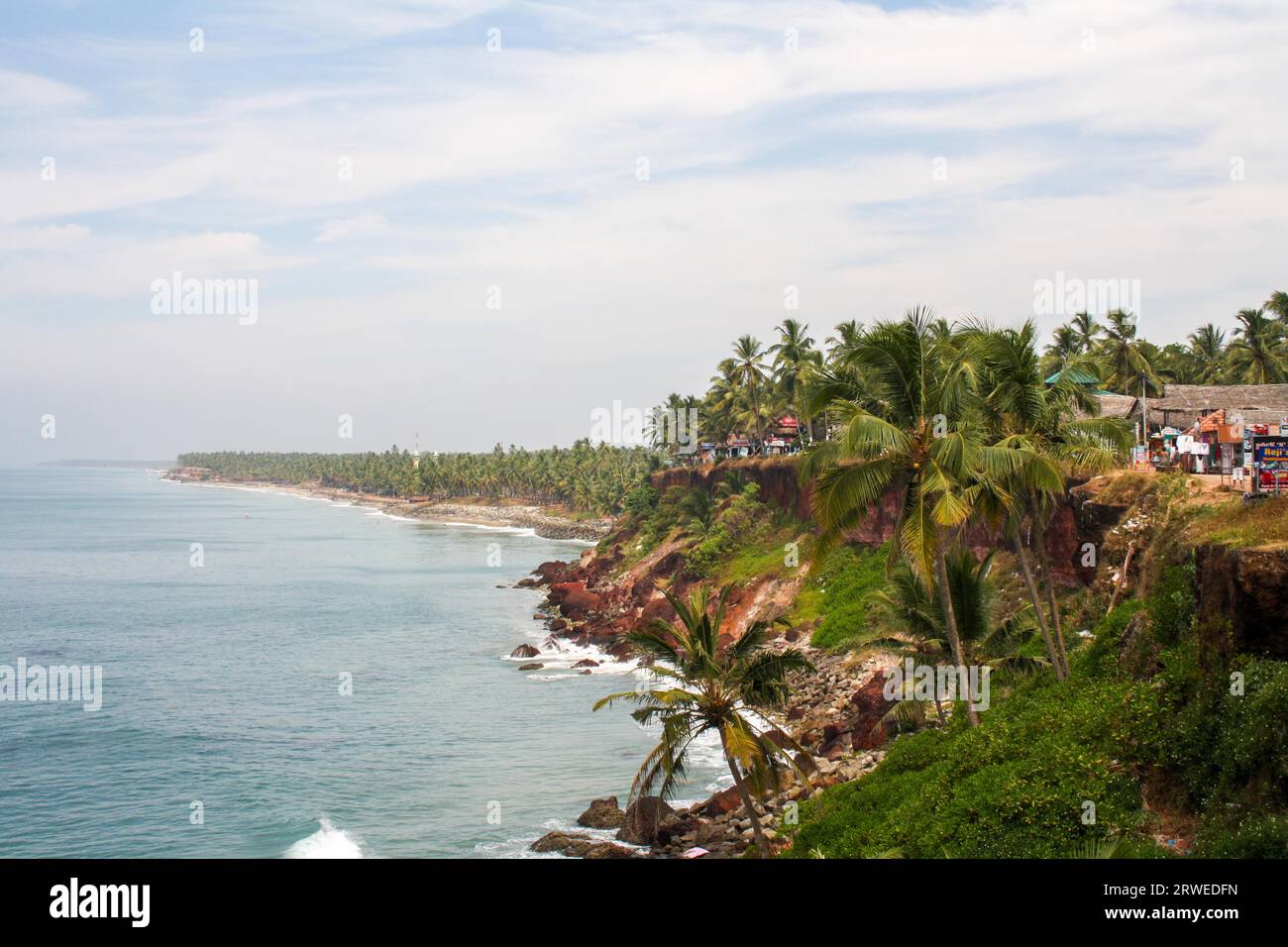 Varkala, India, 1 febbraio 2011: Scogliera rocciosa e alberi tropicali sulla costa Foto Stock