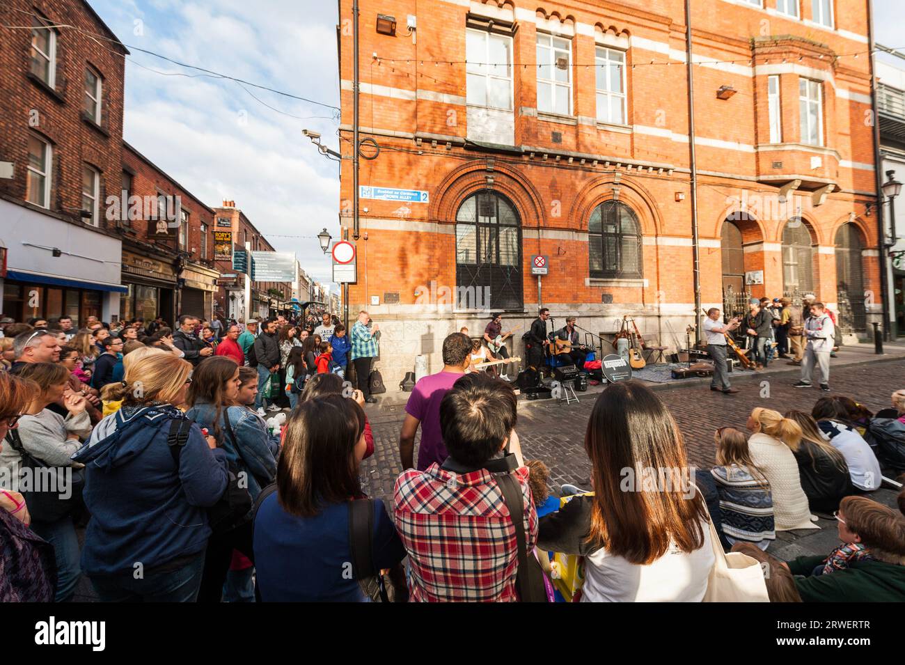 Dublino, Irlanda - 08 16, 2015 mucchio di persone che circondano e girano una band irlandese di strada che improvvisano uno spettacolo musicale Dublin Temple Bar Foto Stock