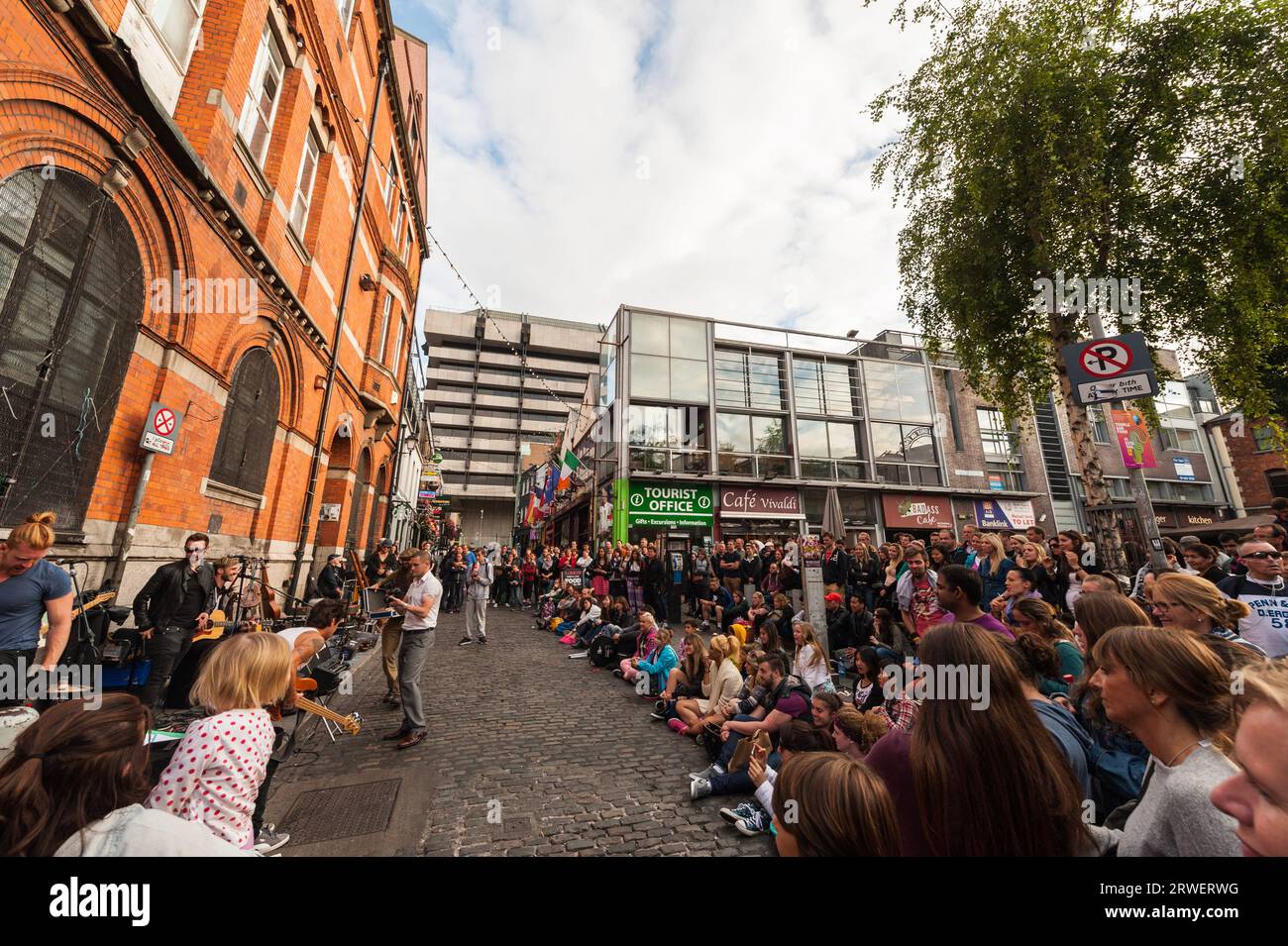 Dublino, Irlanda - 16 agosto 2015 concerto improvvisato al Dublin Temple Bar con una folla di persone sedute e in piedi sui gradini della piazza vicino alla e Foto Stock