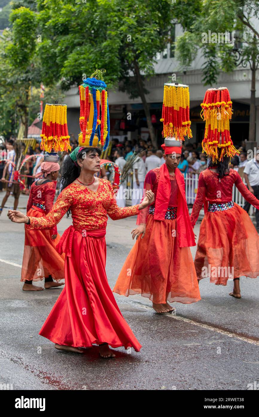 I ballerini Kavadi (indù) si esibiscono lungo una strada di Kandy in Sri Lanka durante il giorno Perahera (grande processione). Foto Stock