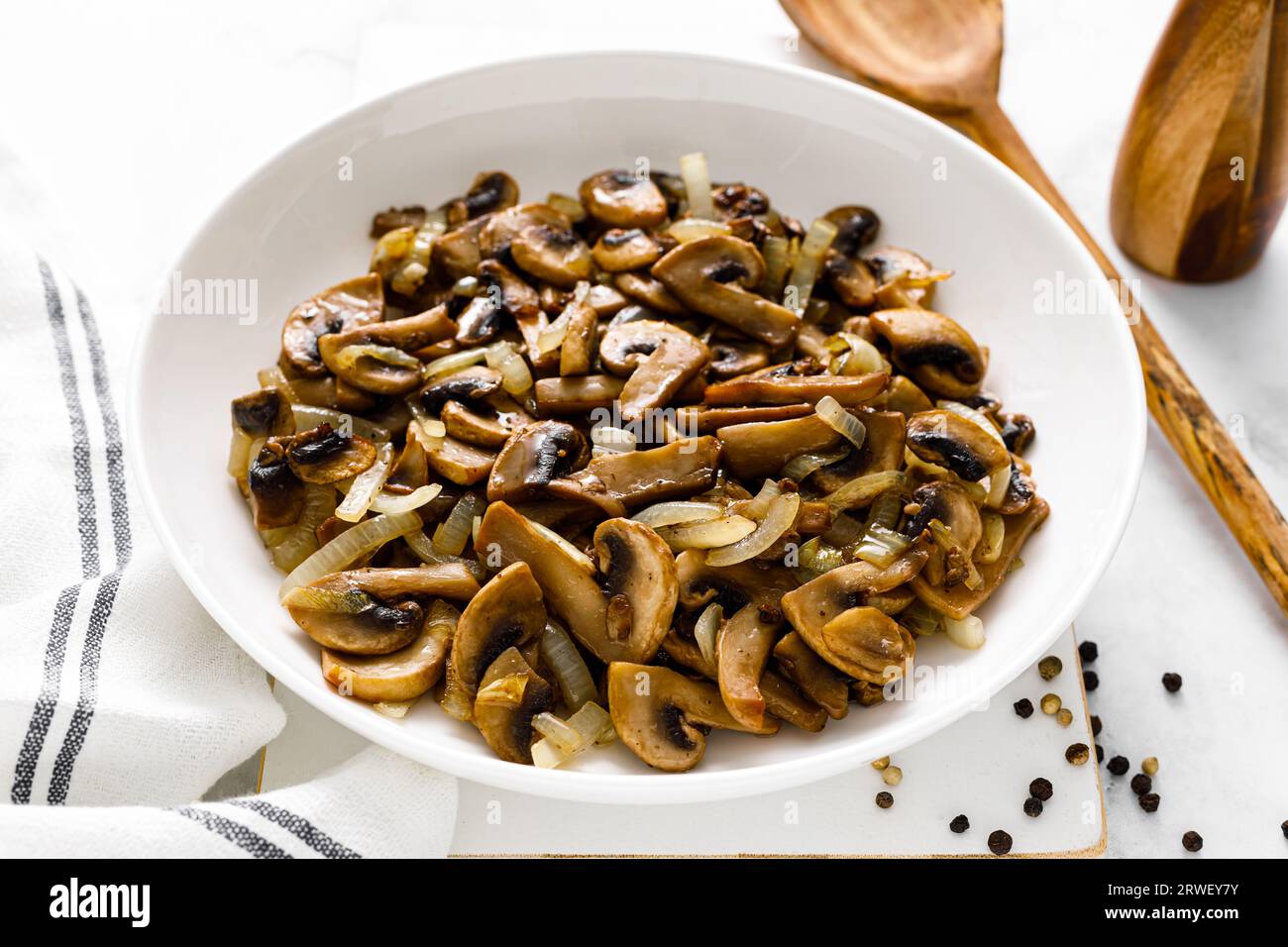 Funghi Champignon saltati con cipolla Foto Stock