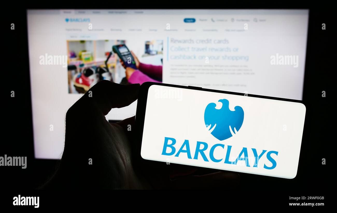 Persona che possiede uno smartphone con il logo della banca universale britannica Barclays plc sullo schermo di fronte al sito Web. Concentrarsi sul display del telefono. Foto Stock