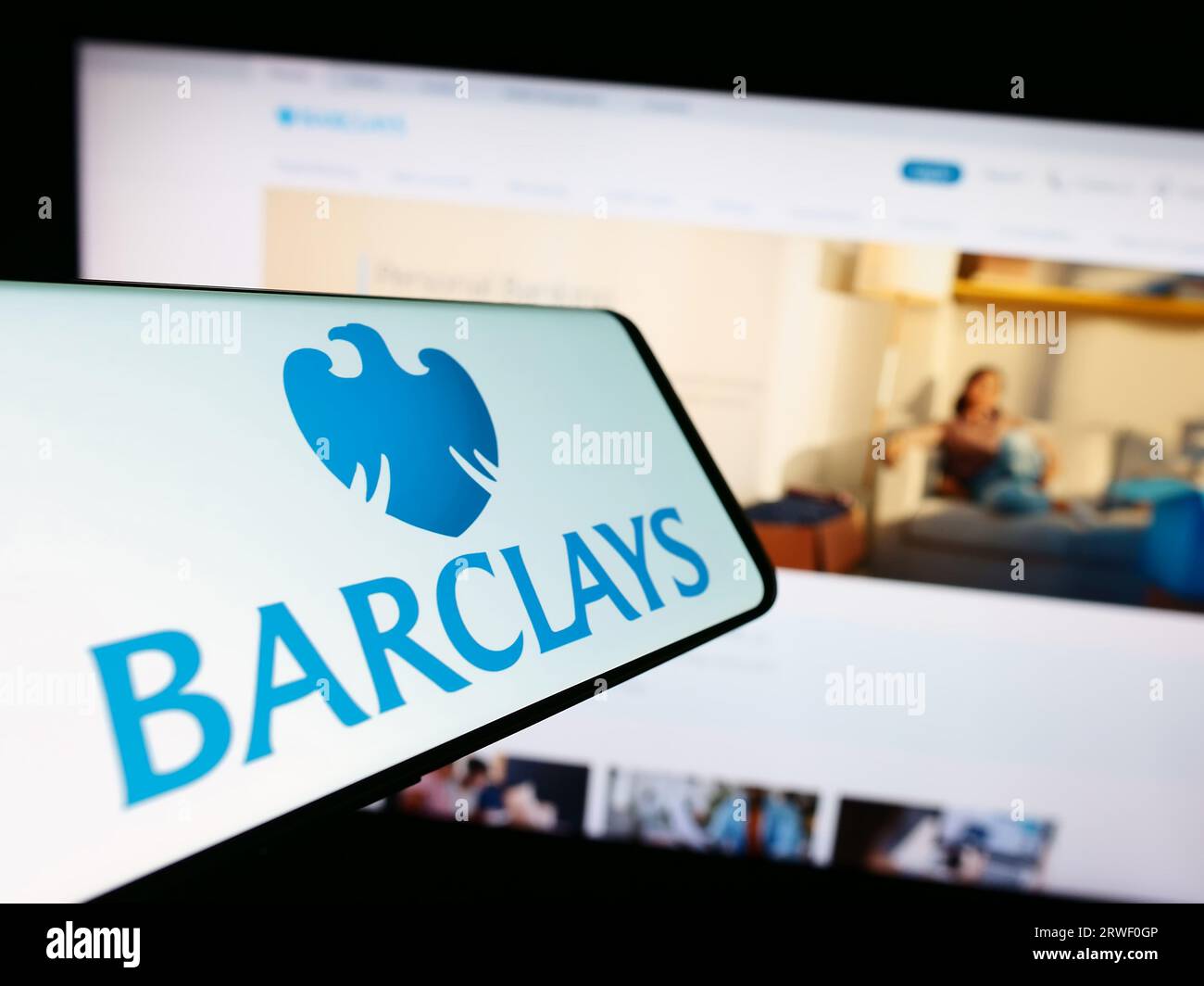 Smartphone con logo della banca universale britannica Barclays plc sullo schermo di fronte al sito Web dell'azienda. Mettere a fuoco il display centrale destro del telefono. Foto Stock