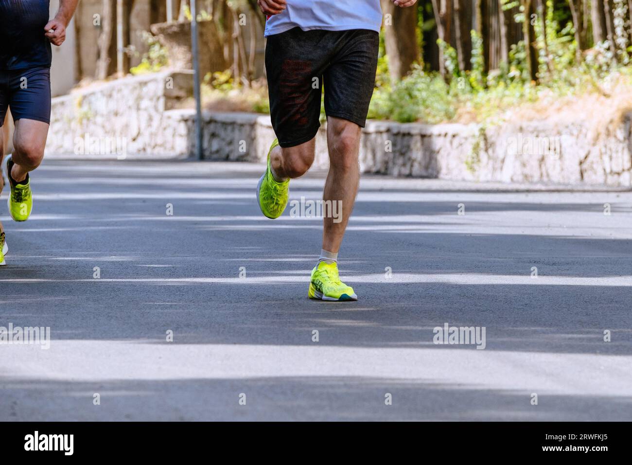 gambe due corridori maschili corrono insieme in una maratona di asfalto Foto Stock