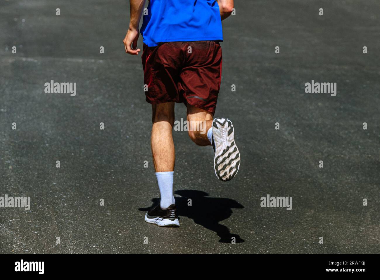 suola di scarpa da running, fondo da runner maschile, asfalto scuro, gara di maratona estiva Foto Stock