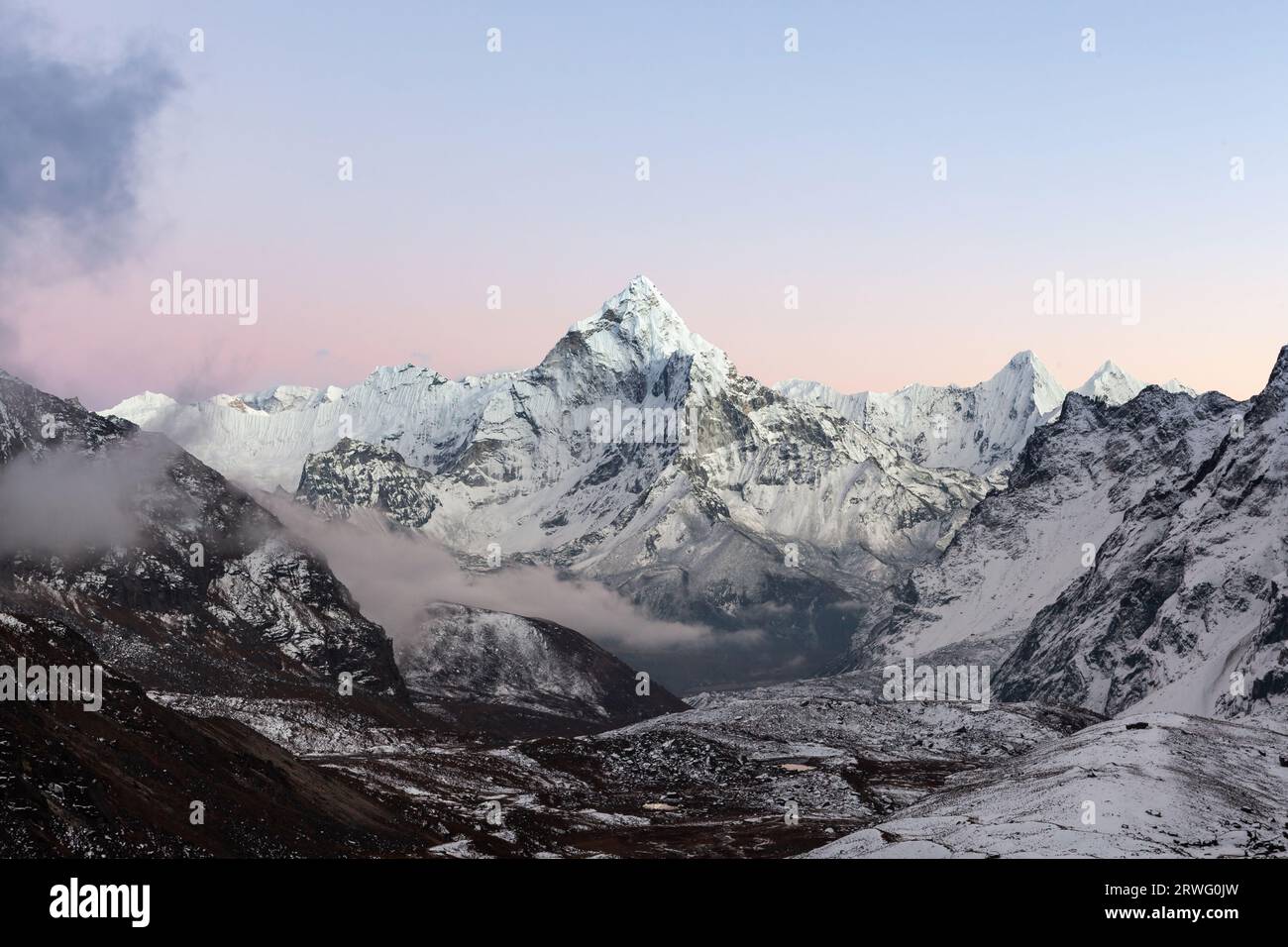 Incredibile Monte ama Dablam in Himalaya, nella zona del monte Everest, sotto il passo Cho la. Tramonto rosa sull'alto picco himalayano. Foto Stock