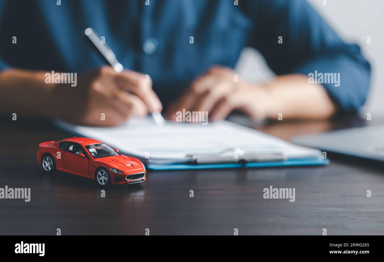 Donna d'affari che firma un documento di assicurazione auto o un documento di leasing. Firma del contratto o dell'accordo. Acquisto o vendita di veicoli nuovi o usati. Auto ke Foto Stock