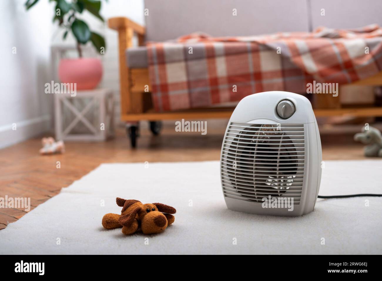 Termoventilatore sul pavimento nel soggiorno con divano sullo sfondo Foto Stock