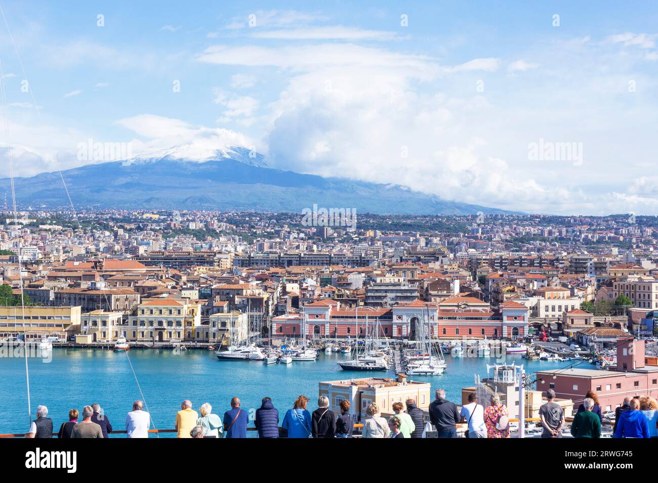 Passeggeri a bordo di una nave da crociera che arrivano al porto di Catania, Sicilia, Italia, Etna sullo sfondo. Foto Stock