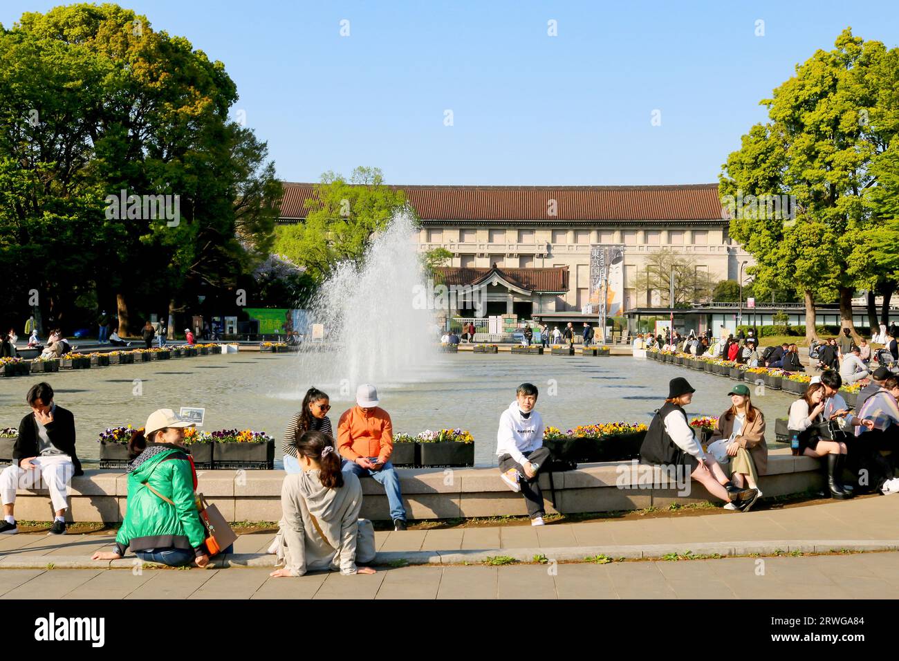 I turisti seduti alla fontana Takenodai di fronte al Museo Nazionale della natura e della Scienza Foto Stock