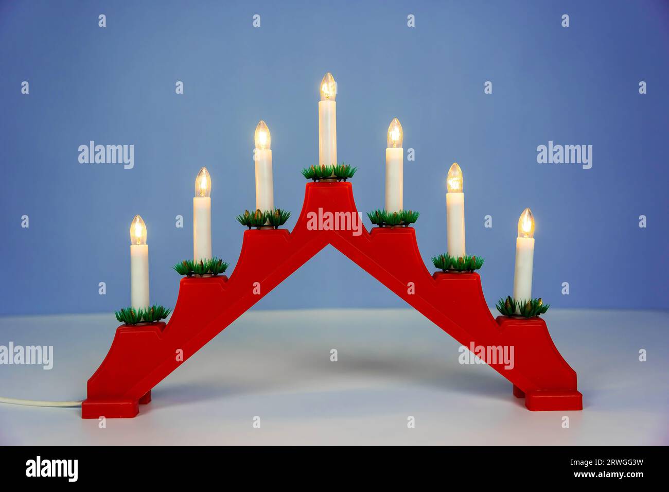 Tradizionale portacandele natalizio con sette candele su sfondo blu invernale. Ponte delle candele di Natale con sette candele. decorazione per t Foto Stock