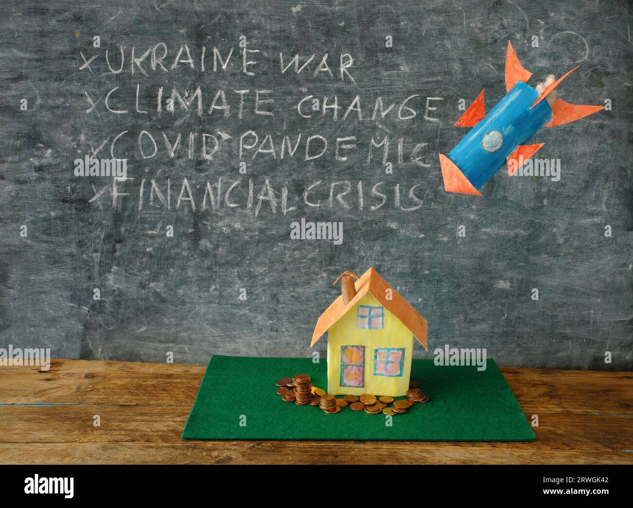 Pericolo per la classe media borghese e il loro stile di vita, crisi globale e minacce varoius. Concetto con casa modello, soldi, un razzo e una lista di t Foto Stock