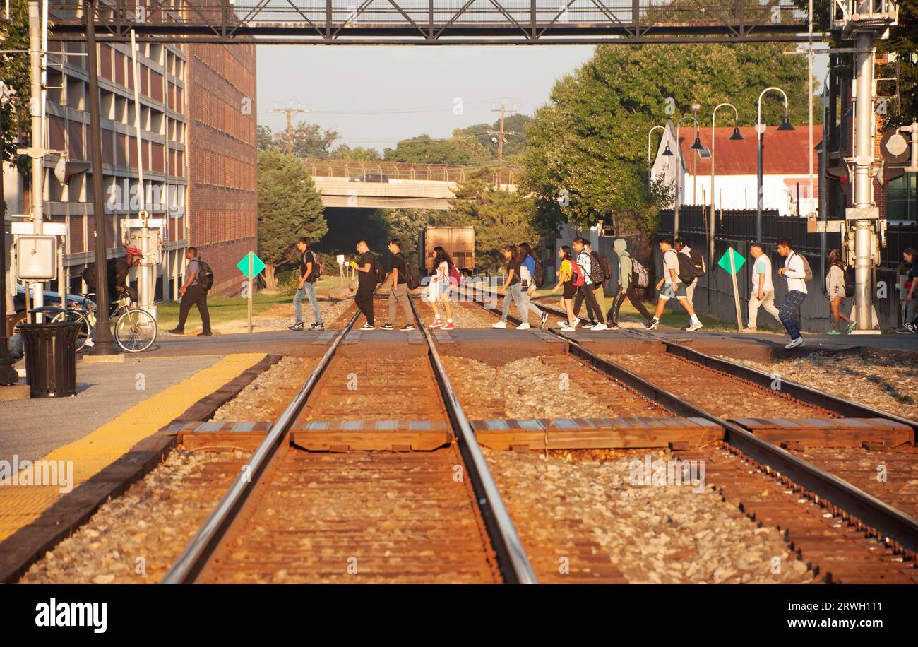 Studenti che camminano fino alla scuola attraversando i binari della ferrovia alla stazione ferroviaria di Gaithersburg, Maryland USA Foto Stock