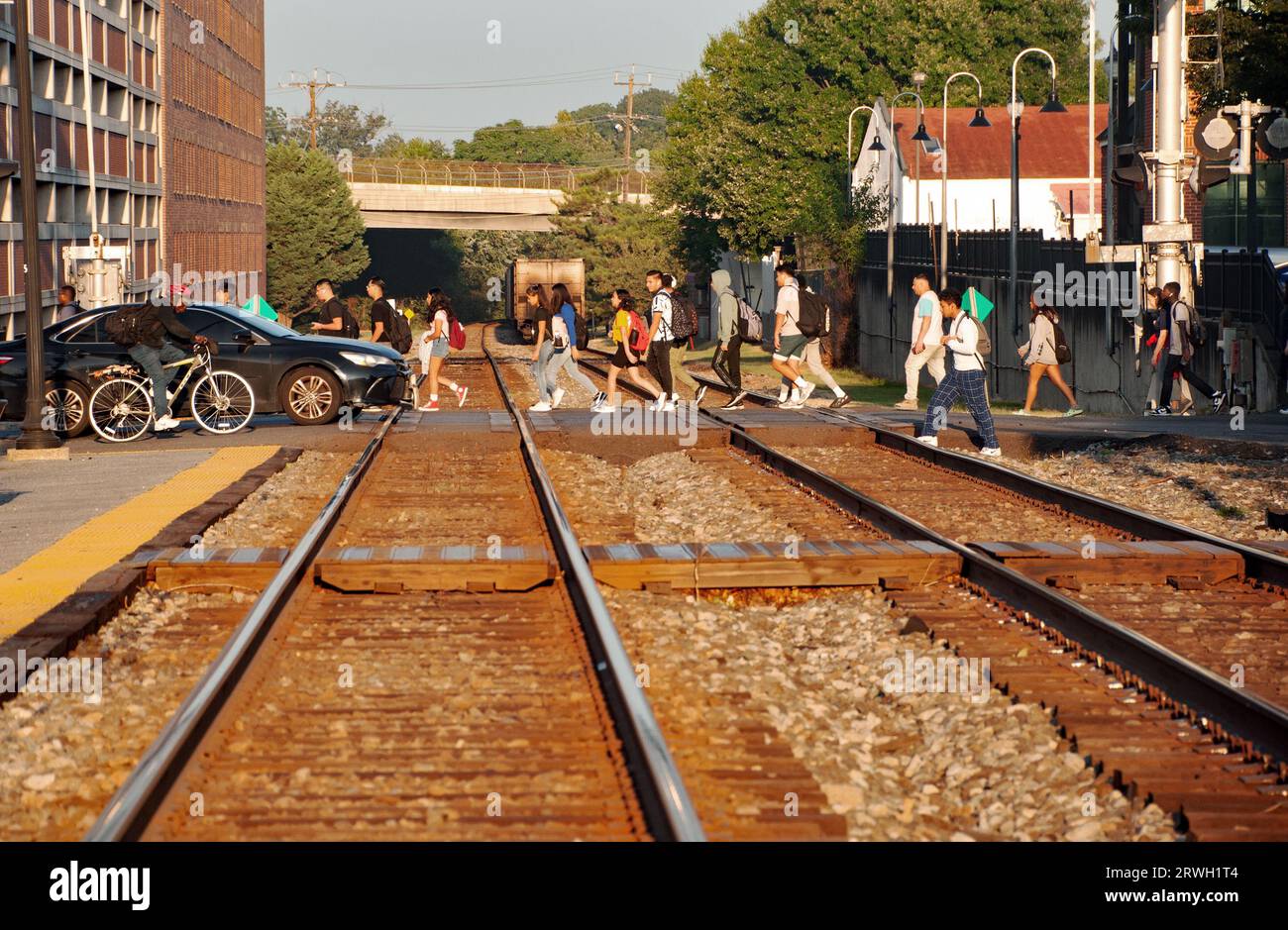 Studenti che camminano fino alla scuola attraversando i binari della ferrovia alla stazione ferroviaria di Gaithersburg, Maryland USA Foto Stock