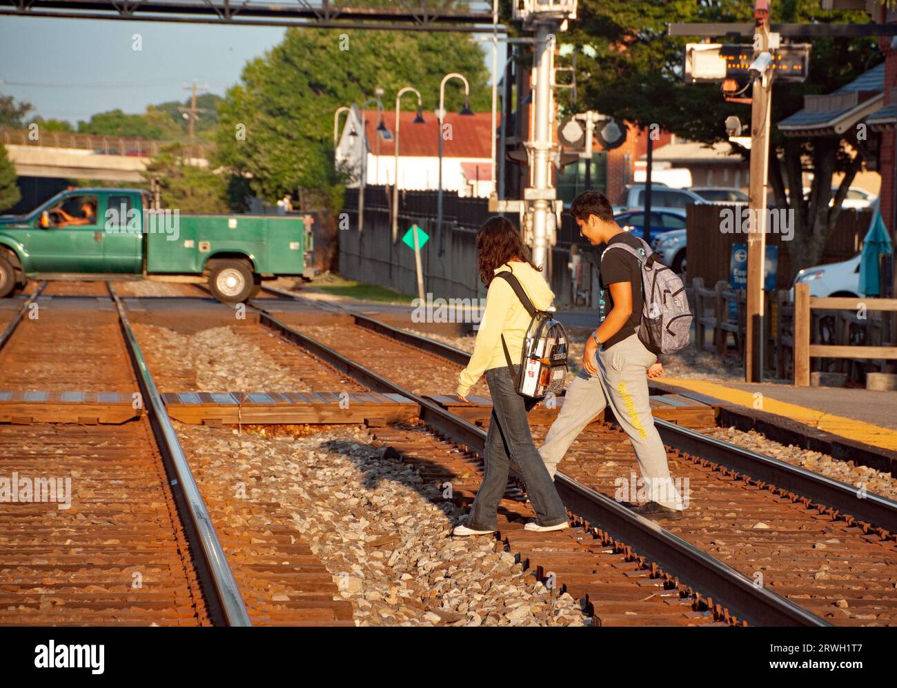 Studenti che camminano fino alla scuola attraversando i binari della ferrovia alla stazione ferroviaria di Gaithersburg, Maryland USA Foto Stock