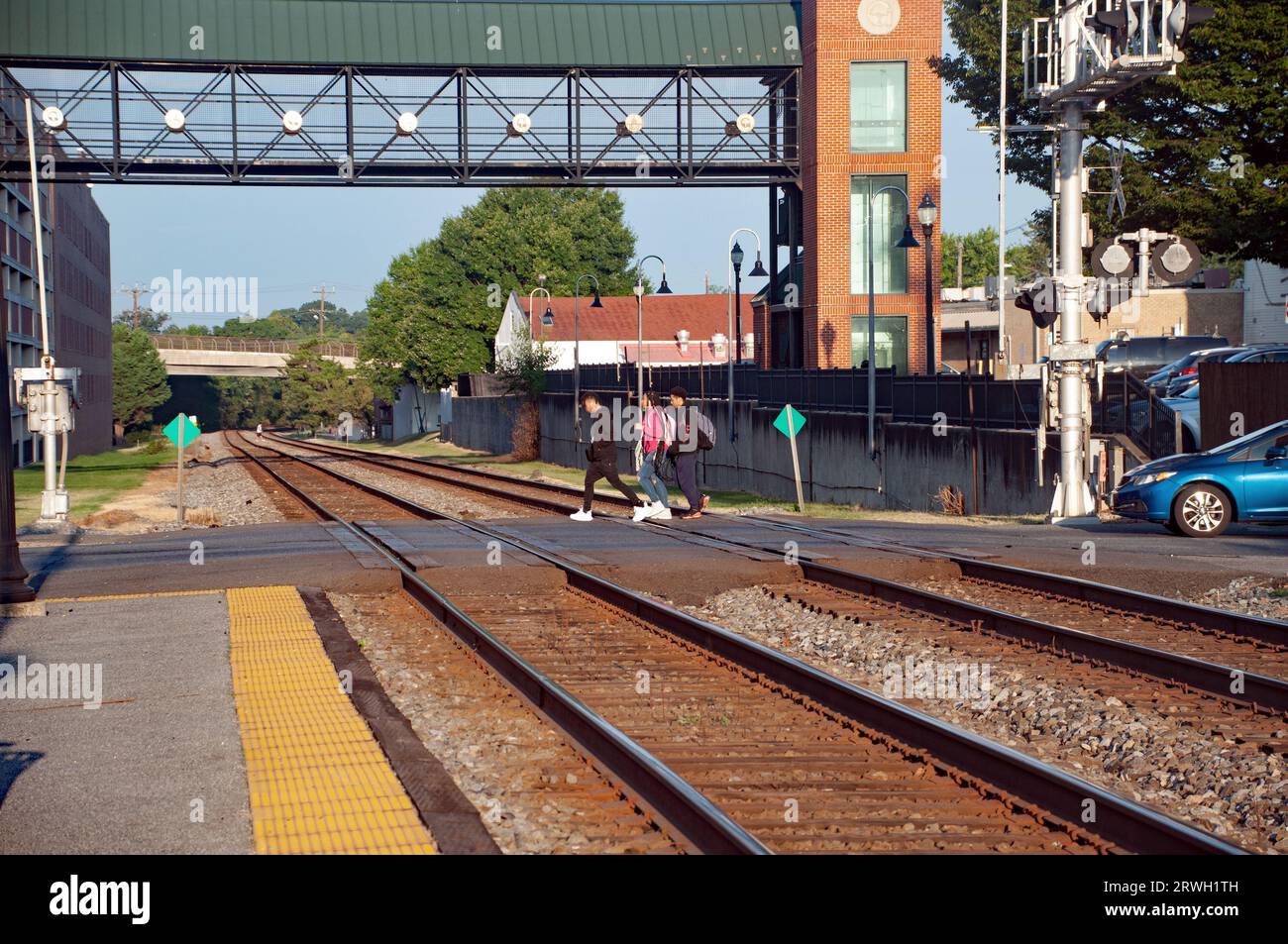 Studenti che camminano fino alla scuola attraversando i binari della ferrovia alla stazione ferroviaria di Gaithersburg, Maryland USA Foto Stock