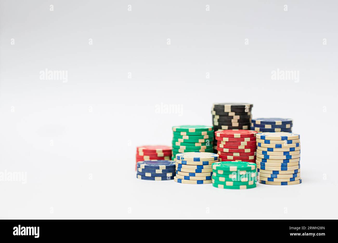 Chip in plastica per casinò impilati su sfondo bianco. Gioco di poker. Foto Stock