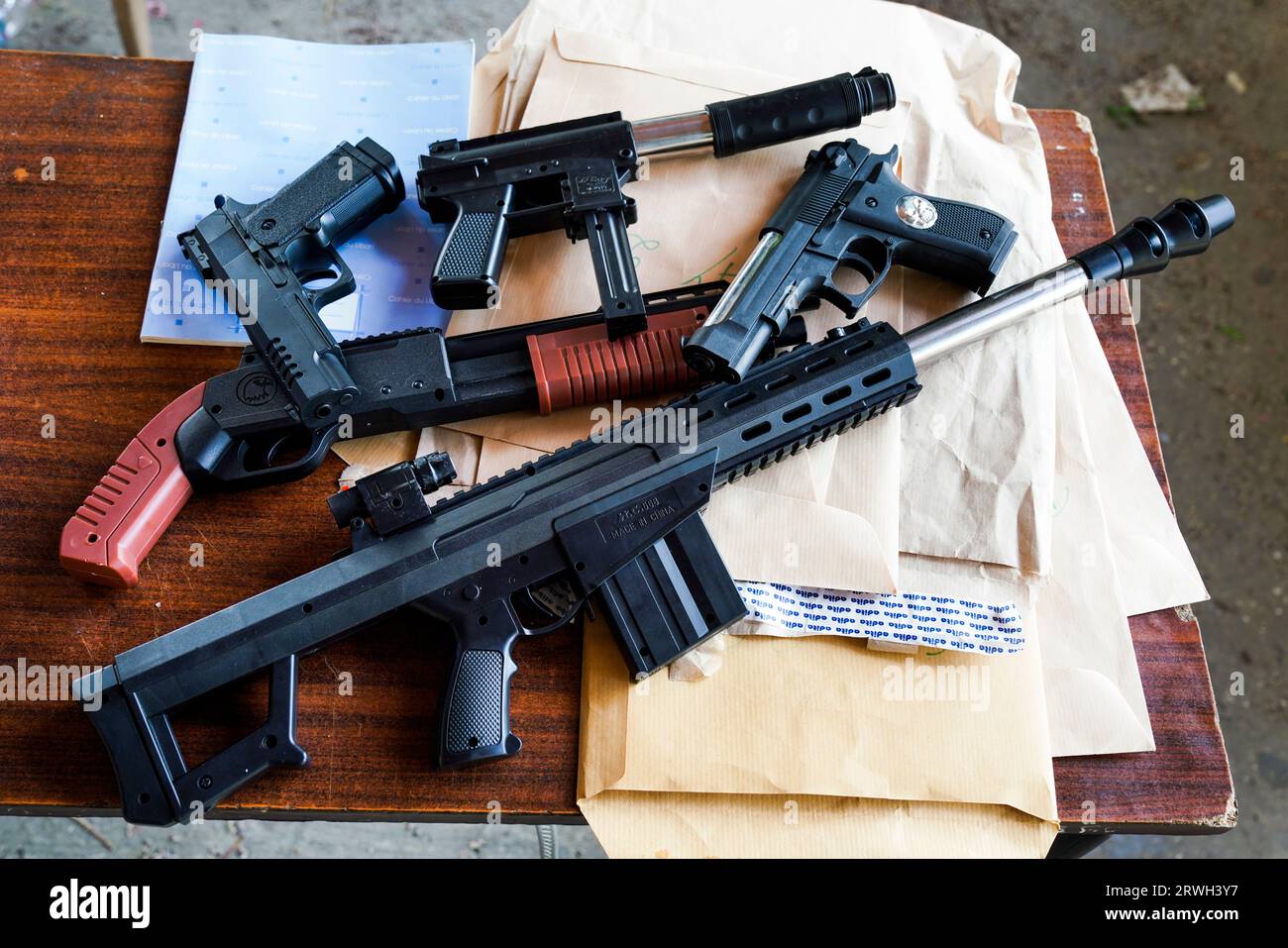 Pistolen und Gewehre als Kinderspielzeug müssen am Eingang zu einem Kinderfest auf dem Schulhof abgegeben werden. Tripoli, Libanon Foto Stock