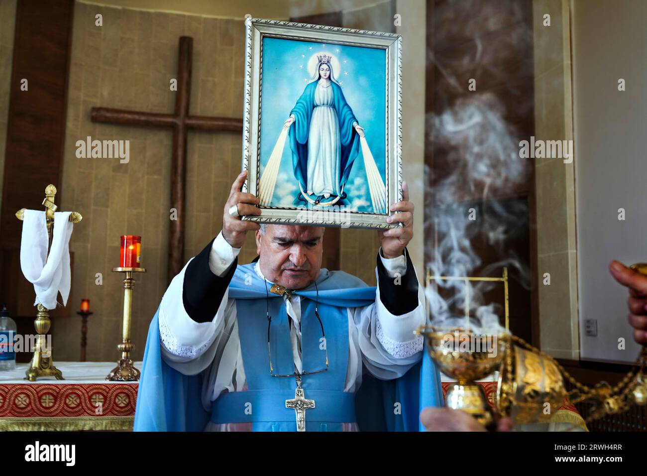 L'Arcivescovo maronita Hanna Rahme di Deir al-Ahmar conserva un'immagine della Vergine Maria durante un servizio presso la chiesa di San Giovanni Battista nel villaggio di Tall Safiya nella piana di Beeka, Libano Foto Stock