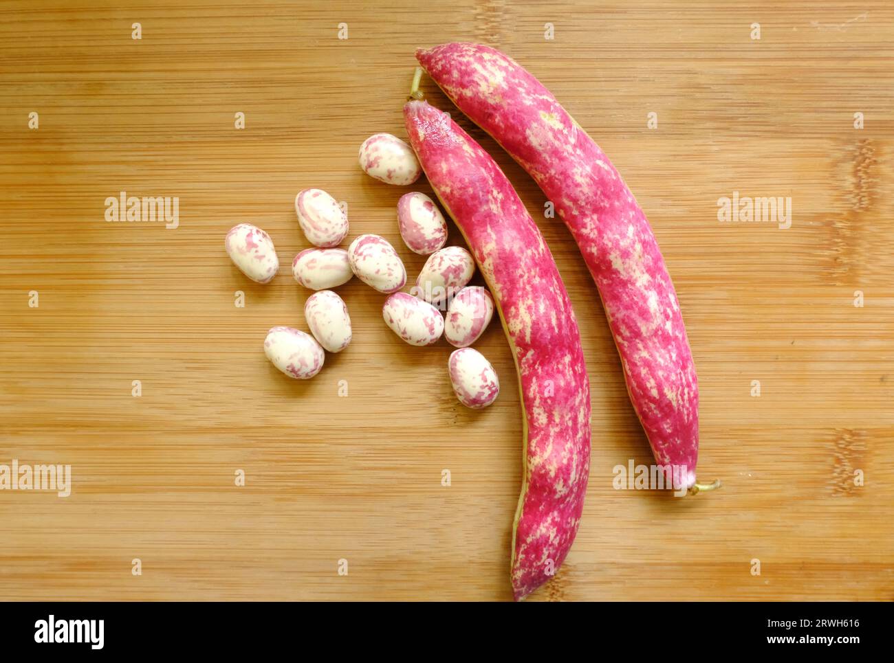 Fagioli Borlotti rossi appena raccolti su tagliere di legno Foto Stock