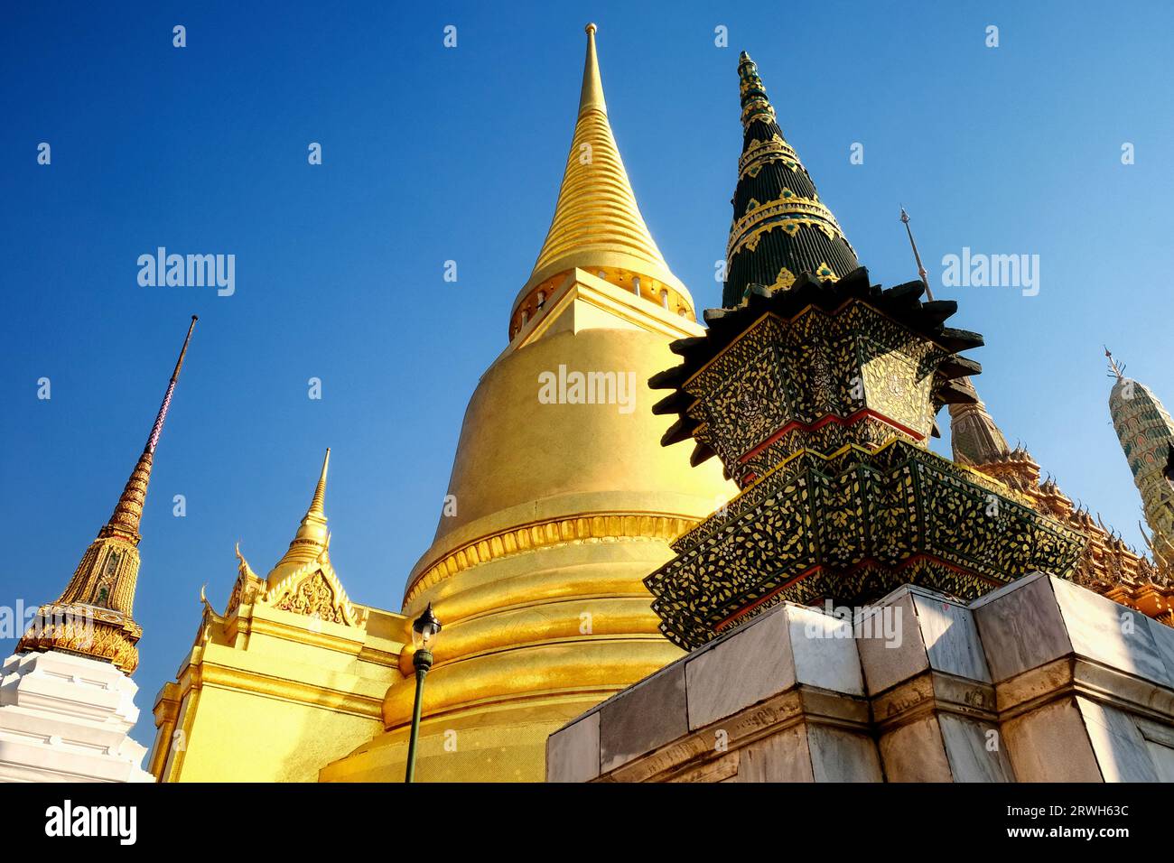 Un tempio in Thailandia. Il tempio ha un grande stupa dorato e diverse guglie ornate più piccole. Ha dettagli complicati. E' una bella rappresentazione Foto Stock
