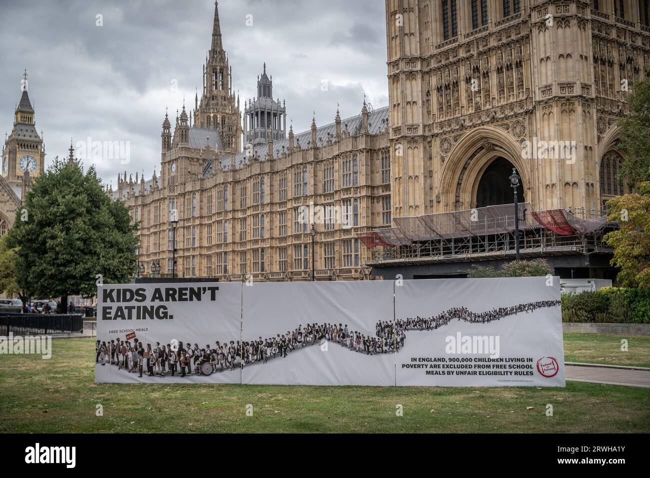 Banner di protesta “Kids Are not Eating” del Child Poverty Action Group vicino agli edifici del Parlamento a Westminster, Londra, Regno Unito Foto Stock