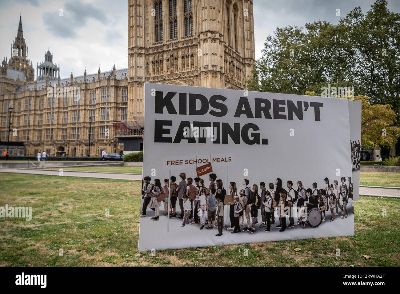 Banner di protesta “Kids Are not Eating” del Child Poverty Action Group vicino agli edifici del Parlamento a Westminster, Londra, Regno Unito Foto Stock