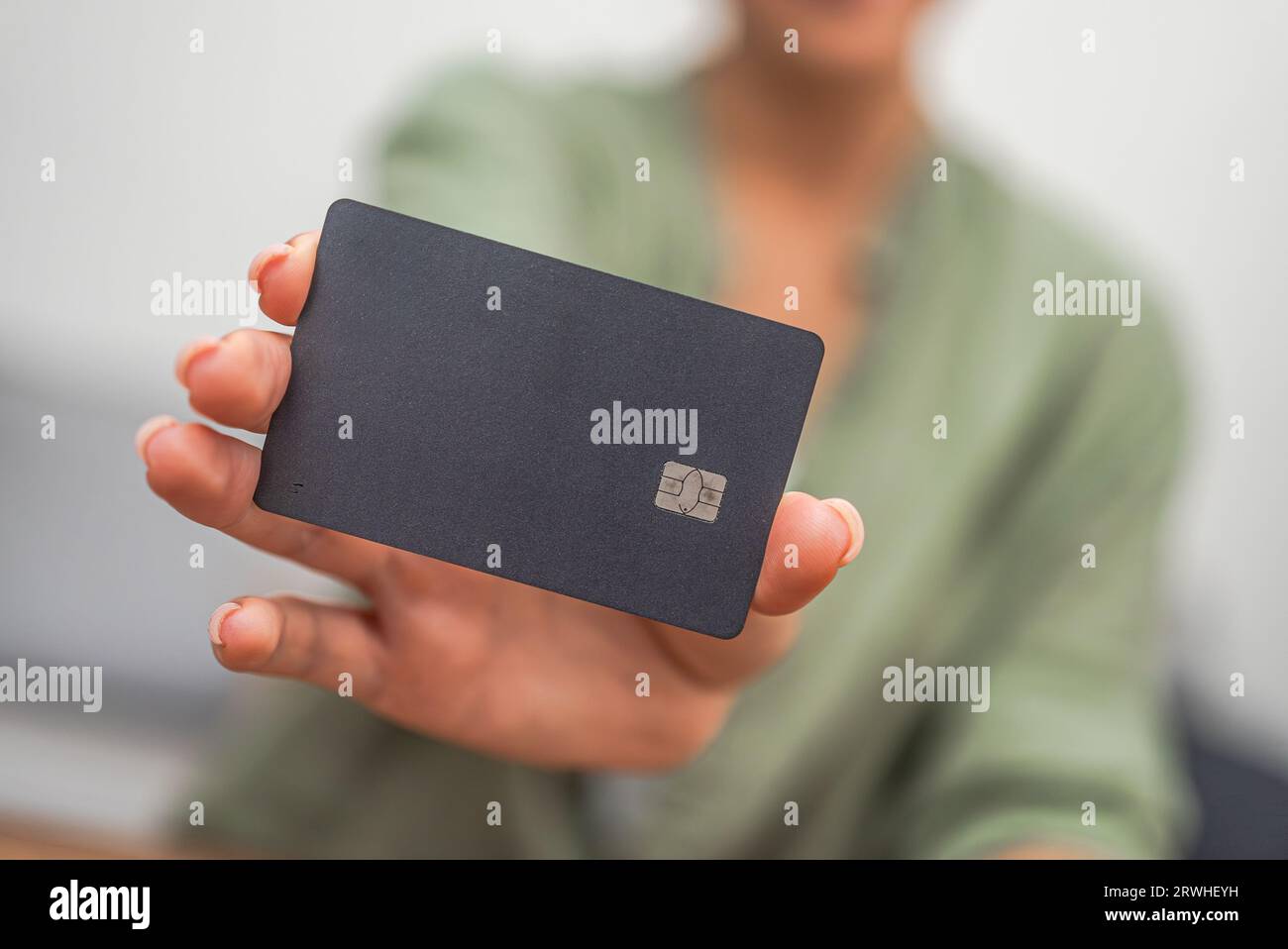 Carta di credito oscura per effettuare pagamenti offline e online nei negozi nelle mani di un acquirente donna Foto Stock