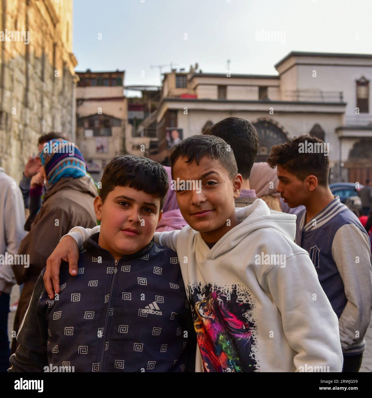 Bambini locali che si mettono in posa per una foto nella piazza all'esterno del portico occidentale della moschea omayyade a Damasco, Siria Foto Stock