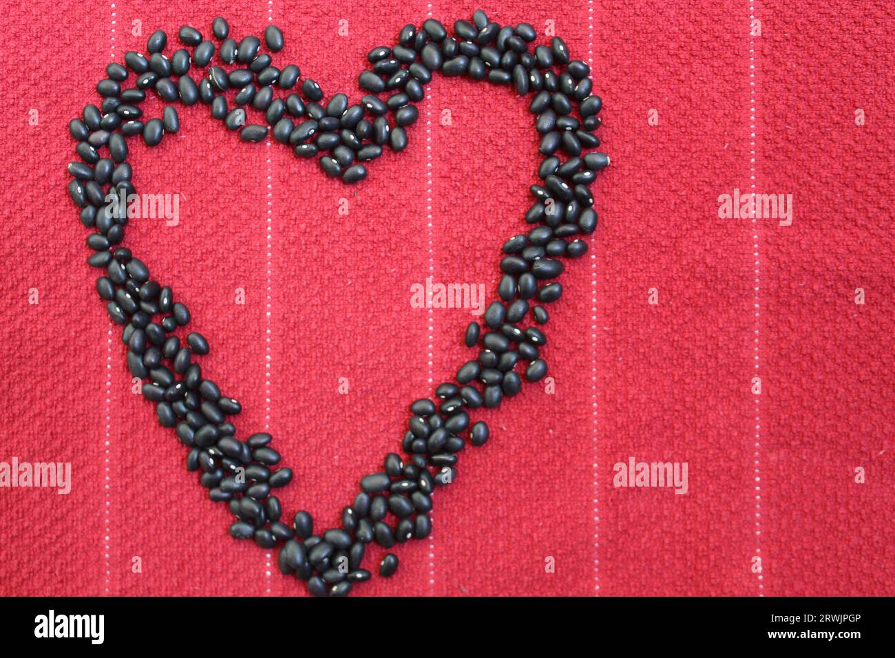 Ti amo, cuore di fagioli neri su sfondo rosso Foto Stock