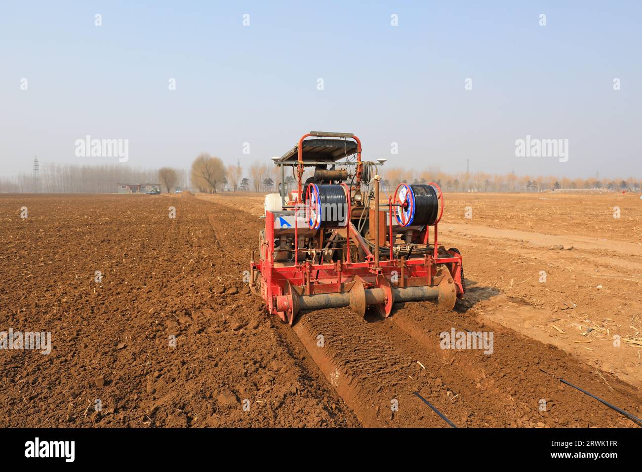 LUANNAN COUNTY, Cina - 9 marzo 2022: Gli agricoltori guidano macchinari agricoli per riordinare la terra e prepararsi a piantare cavolo cinese sul campo, NOR Foto Stock