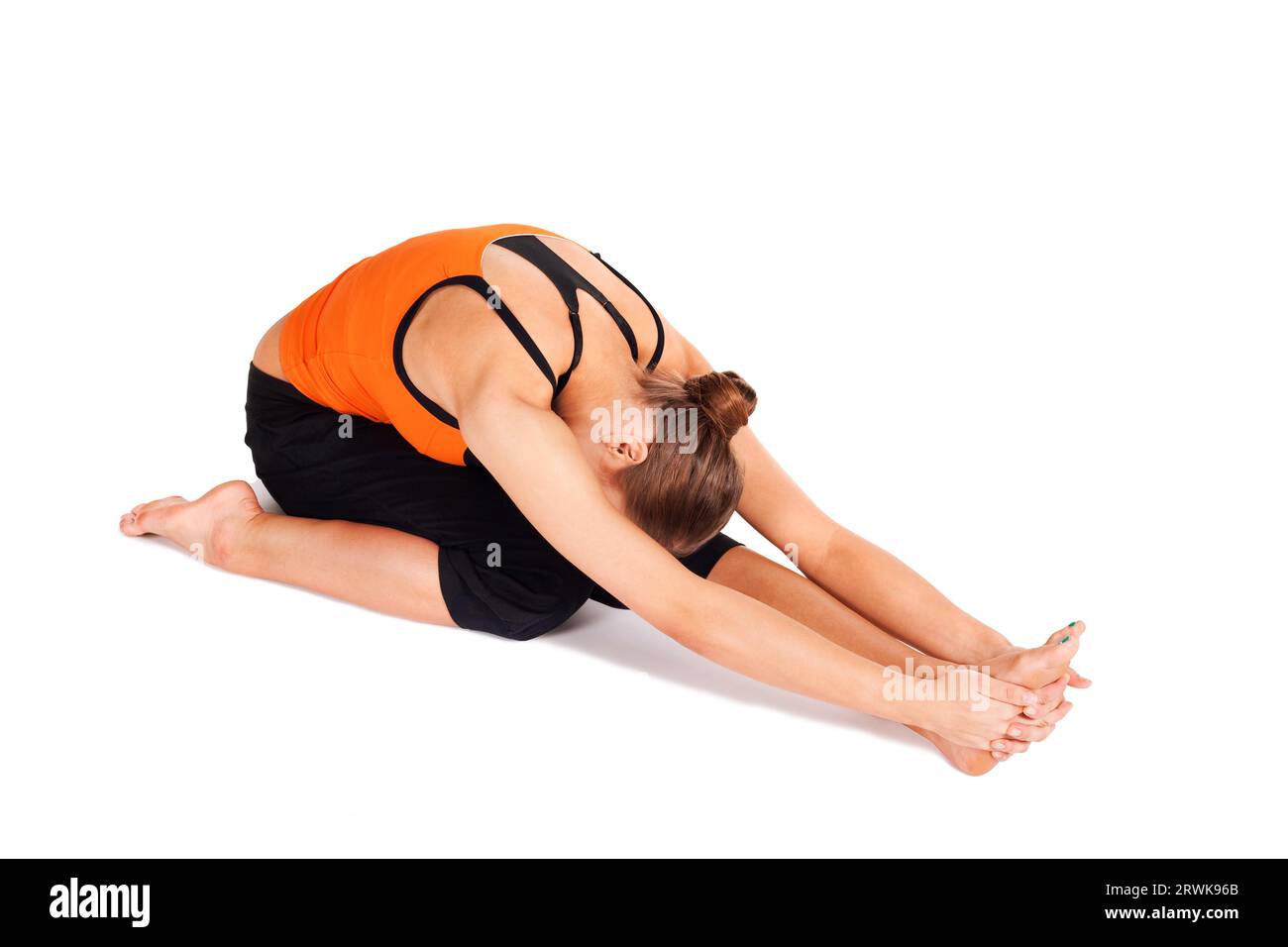 Donna che fa un esercizio di yoga chiamato curvatura anteriore a tre angolate, nome sanscrito: Trianga Mukhaikapada Pashchimottanasana, grande posa come sciatica Foto Stock