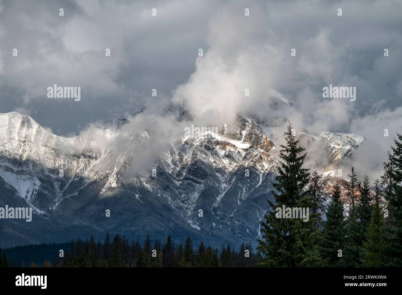 Maestosa vista delle montagne vicino a Jasper ricoperta di neve e splendide nuvole Foto Stock