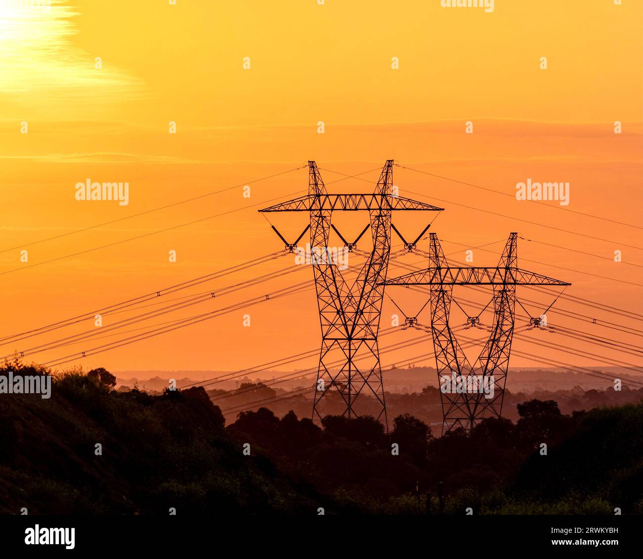Torri di trasmissione ad alta tensione in un tramonto mozzafiato Foto Stock