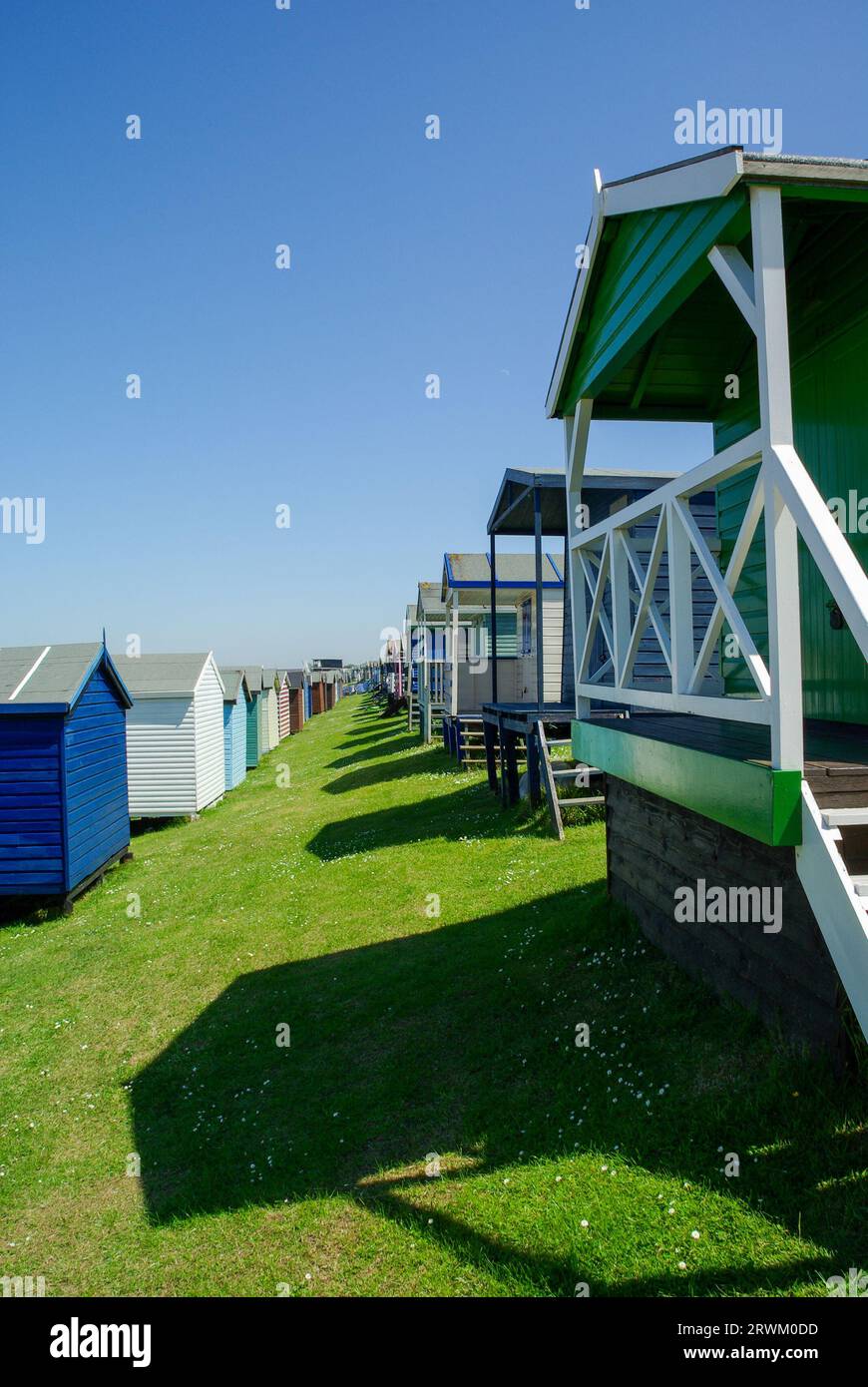 Piccole case sulla spiaggia di Tankerton sulle pendici di Tankerton sul lungomare di Whitstable, Kent, Regno Unito. Capanne in legno rialzate con vista mare nelle giornate di sole blu Foto Stock