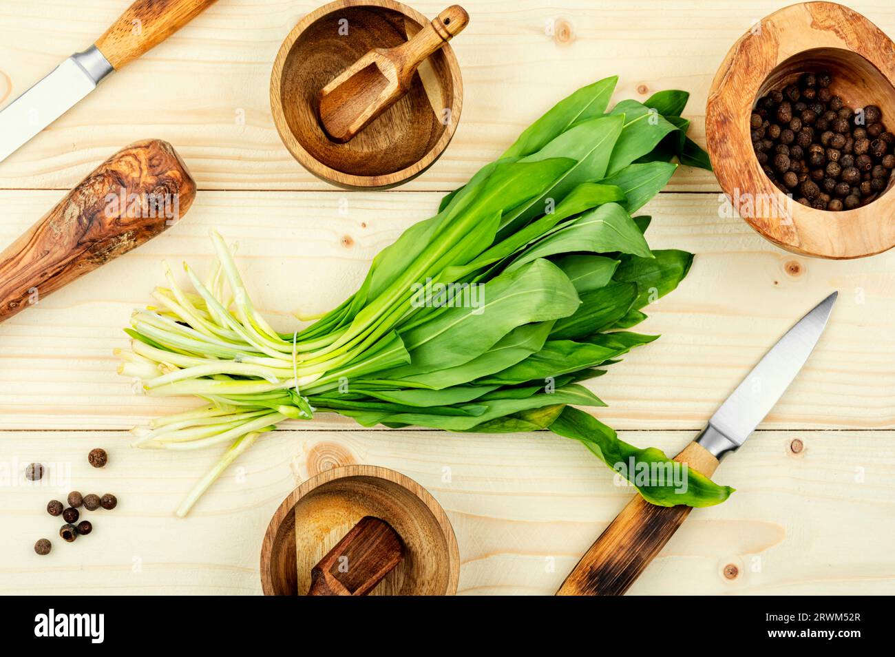 Aglio selvatico fresco su tavola rustica d'annata, piatti all'aglio selvatico. Cucina sana, vista dall'alto. Foto Stock