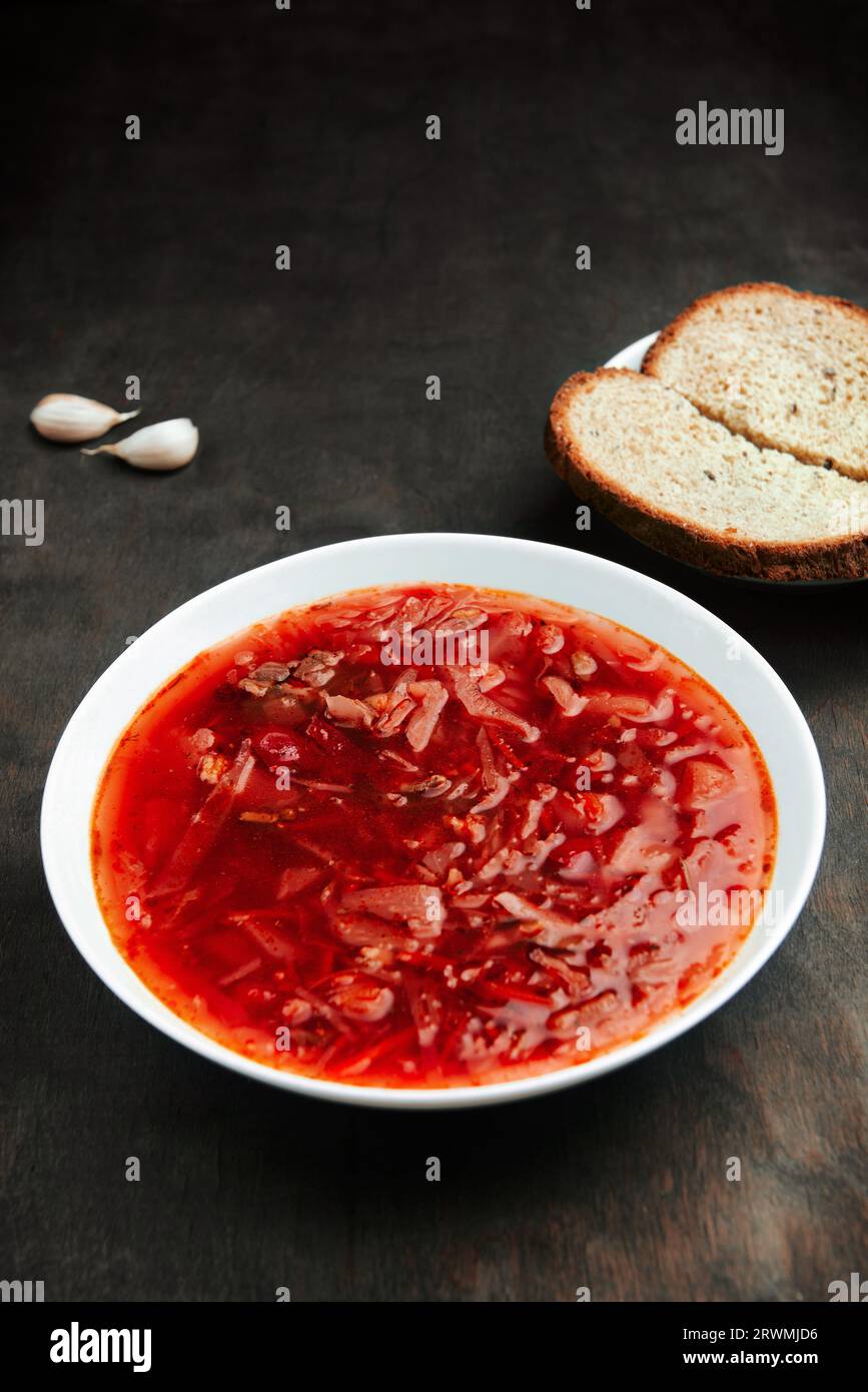 Borsch in piatto su un tavolo ruvido di legno, una zuppa tradizionale russa e Ucraina. Borscht, un piatto di cucina slava Foto Stock