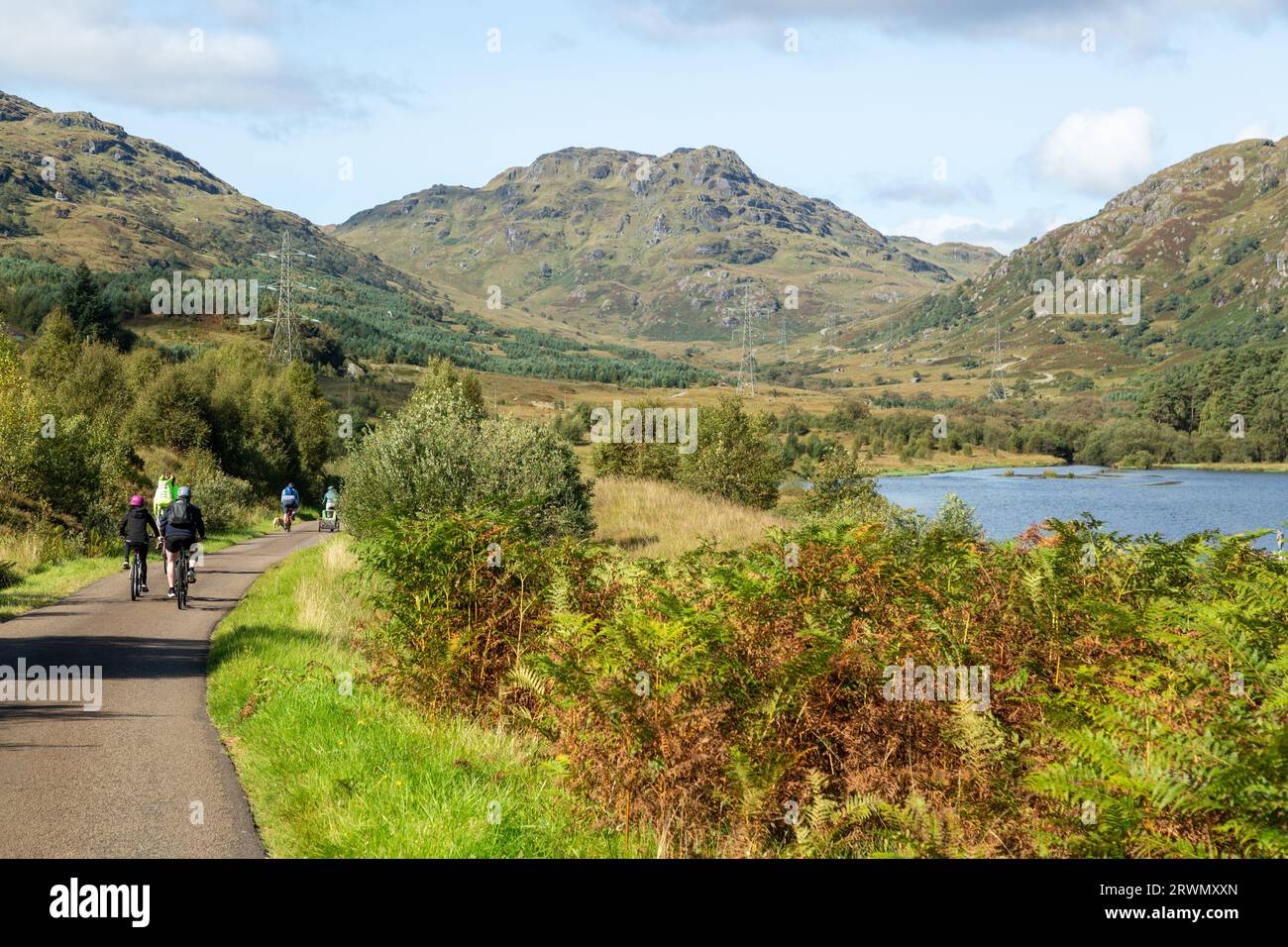 Ciclisti sulla strada vicino a Loch Katrine nel Parco Nazionale del Trossachs, Stirling, Scozia Foto Stock
