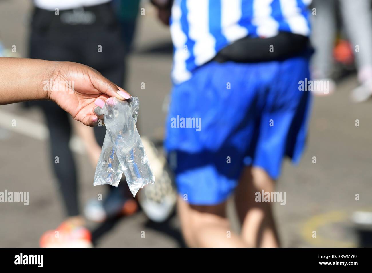Confezione di plastica per mani umane, acqua alla stazione di ristoro, maratona dei 96 compagni, Sudafrica, idratazione degli atleti, corsa a lunga distanza Foto Stock