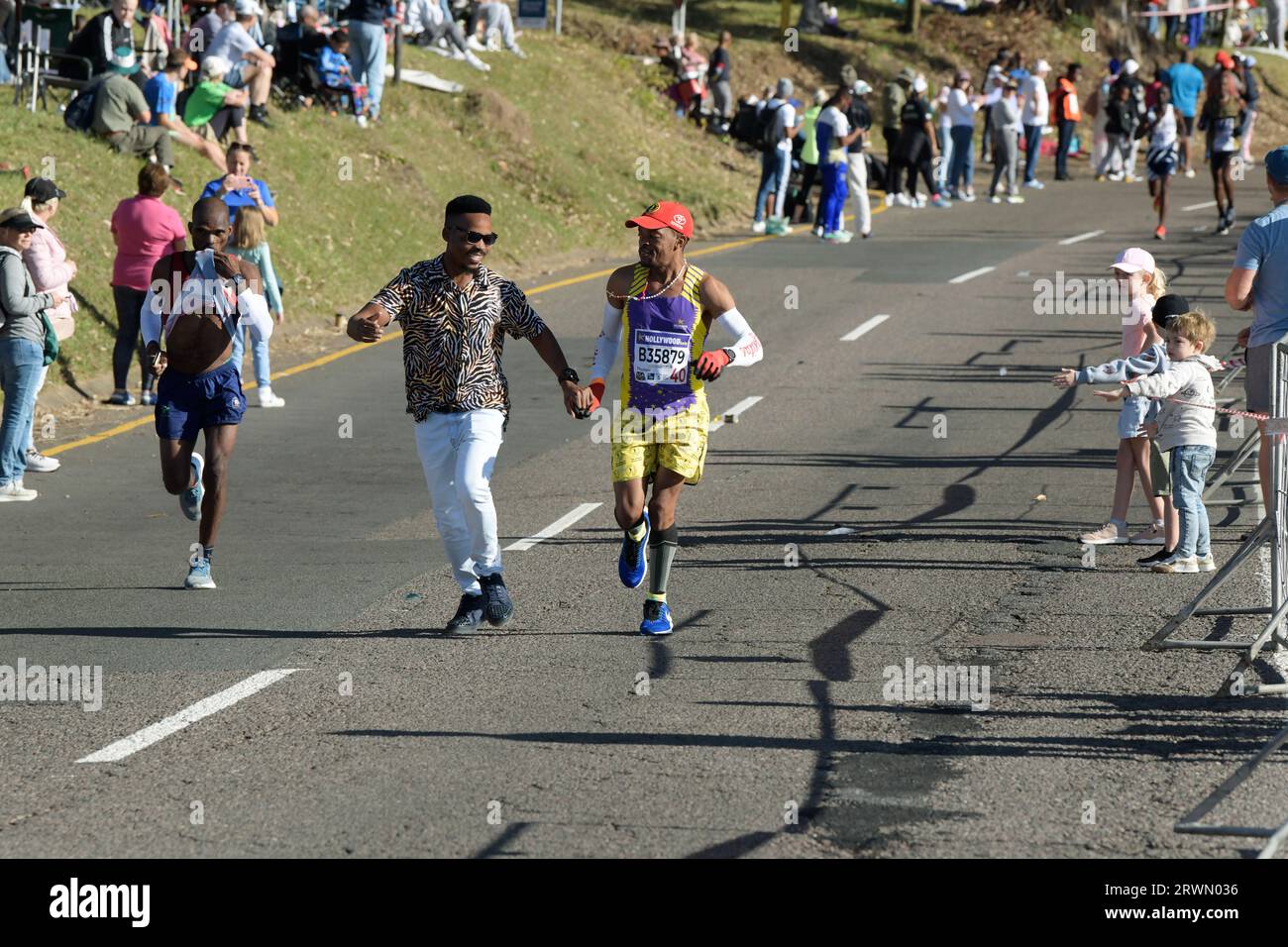 Spettatore che dà sostegno morale al corridore in gara su strada a lunga distanza, 96th Comrades Marathon 2023, Durban, Sud Africa, emozioni umane, persone nello sport Foto Stock