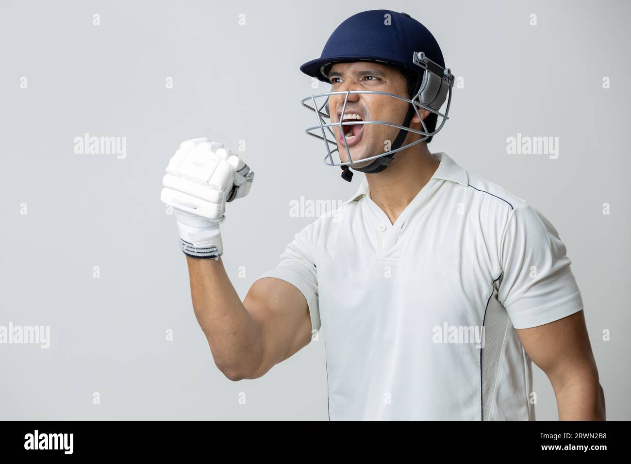 Uomo in abito da cricket con casco che urla gioia e rabbia, concetto di coppa del mondo Cricketer Foto Stock
