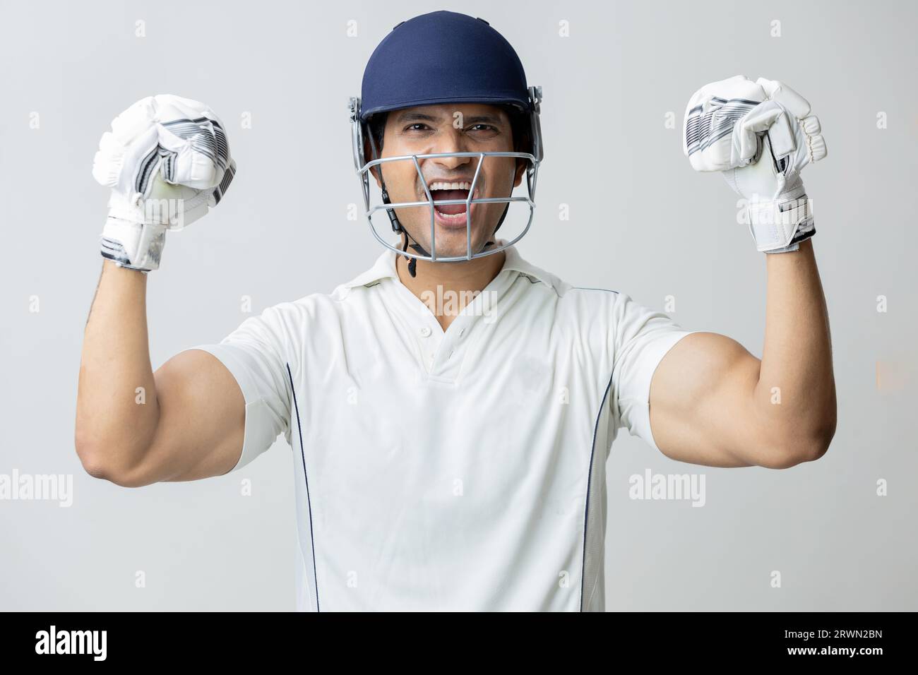 Uomo in abito da cricket con casco che urla di gioia e rabbia guardando verso la macchina fotografica, concetto di coppa del mondo Cricketer Foto Stock