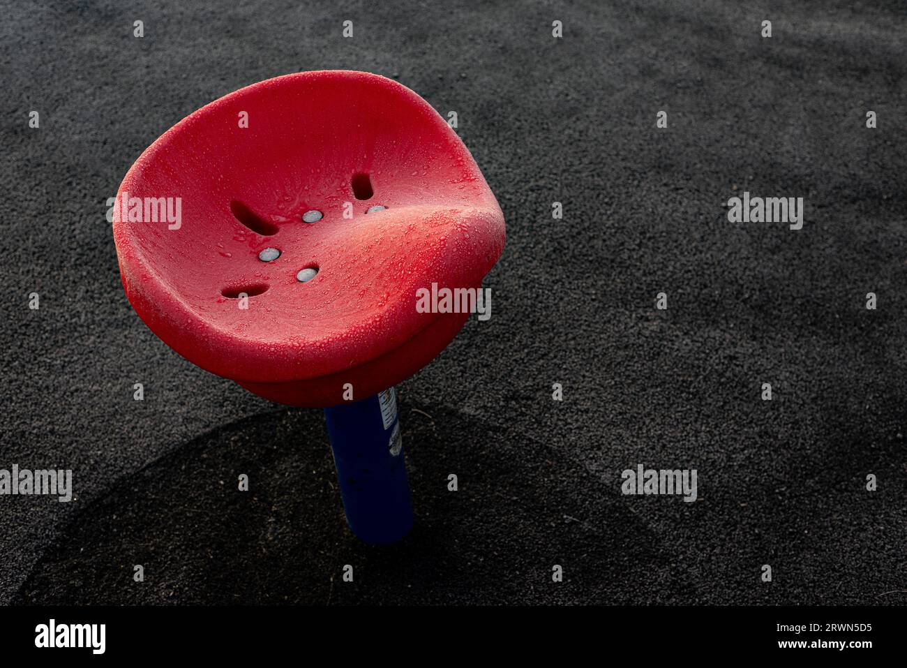 Seggiolino rosso per bambini nel parco giochi ghiacciato Foto Stock