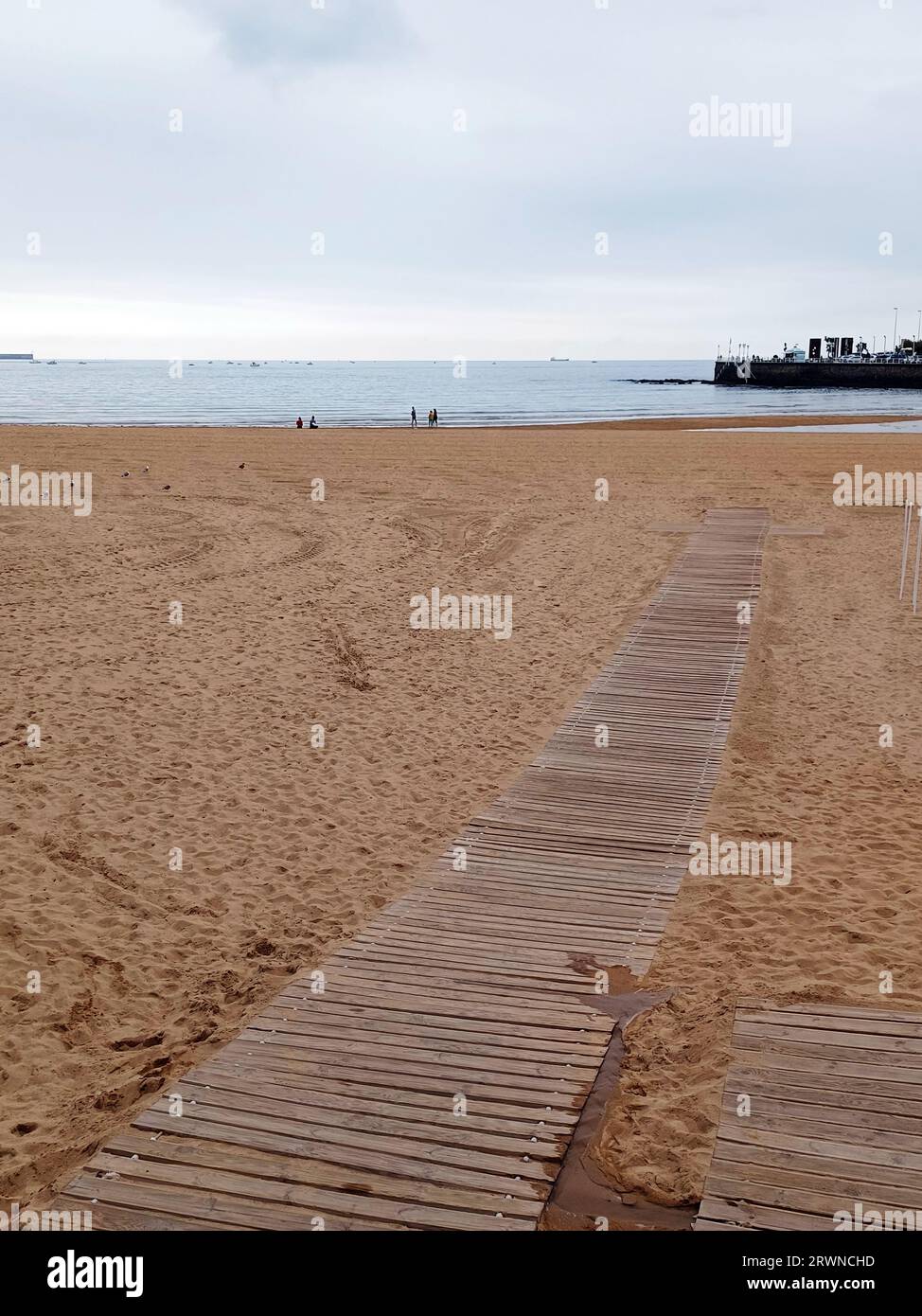 Sentiero in legno vuoto sulla sabbia. Spiaggia di San Lorenzo, Gijon. Spagna Foto Stock