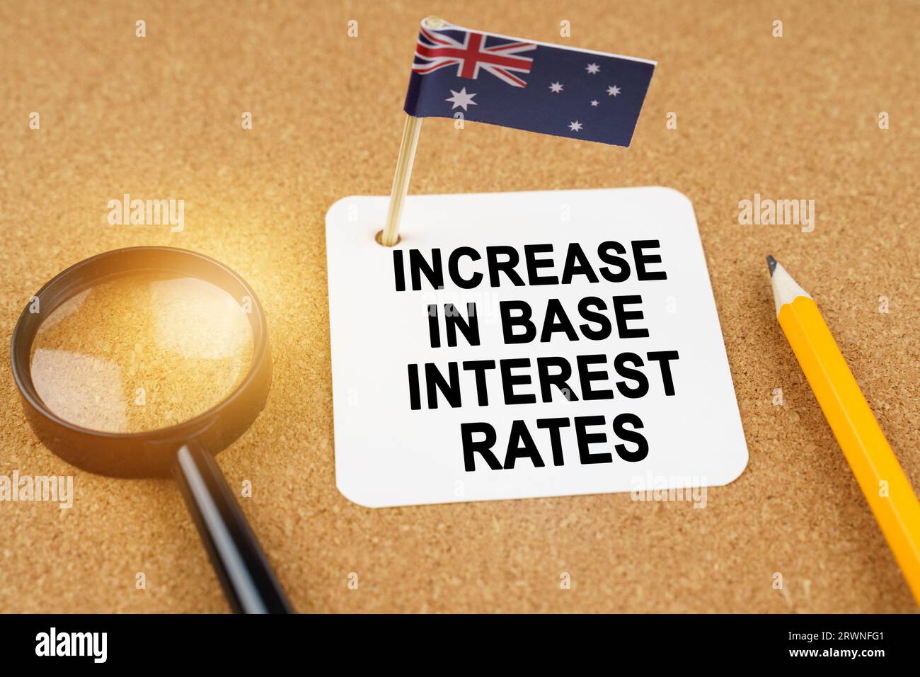 Economia e finanza. Sul tavolo ci sono una lente d'ingrandimento, una matita, la bandiera dell'Australia e un foglio di carta con l'iscrizione - Increase Foto Stock