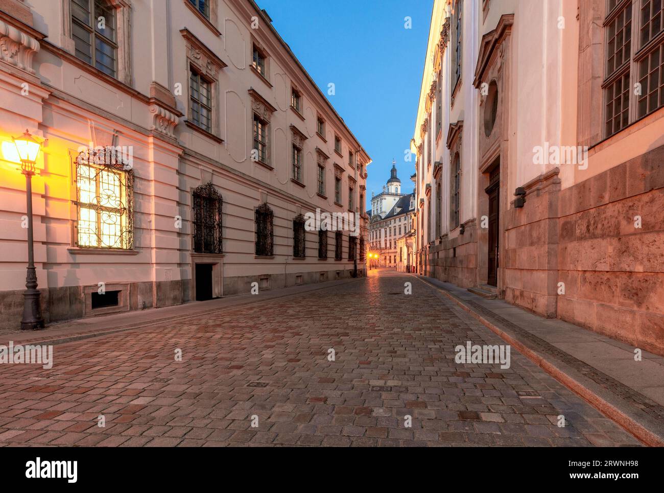 Una vecchia strada stretta con una lanterna in fiamme vicino alla University Square di Breslavia all'alba. Polonia. Foto Stock