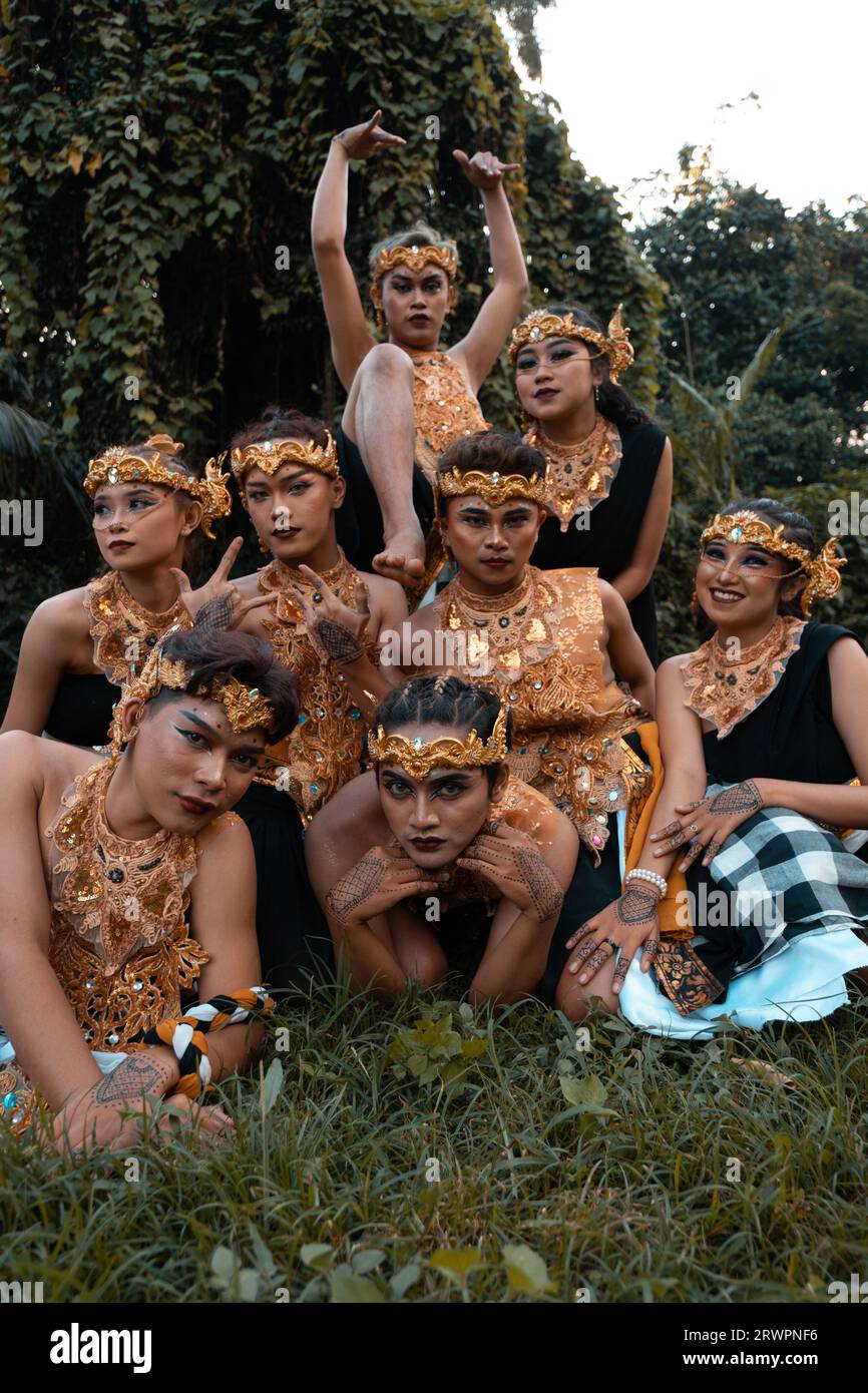 I balinesi si divertono insieme ai loro amici in costumi dorati dopo lo spettacolo di danza all'interno del villaggio Foto Stock