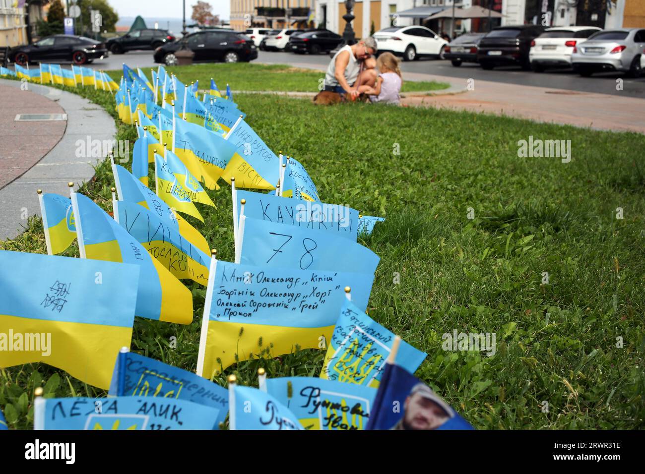 Odessa, Ucraina. 20 settembre 2023. La gente siede accanto alle bandiere dell'Ucraina con i nomi dei soldati morti scritti, installati nel terreno in memoria dei soldati caduti delle forze Armate dell'Ucraina vicino al luogo in cui si trovava il Monumento ai fondatori di Odessa (imperatrice russa Caterina II). Credito: SOPA Images Limited/Alamy Live News Foto Stock